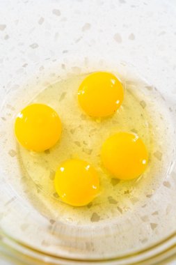 Basit bir vanilyalı kek pişirmek için ıslak malzemeleri küçük bir bardakta karıştırıyorum..