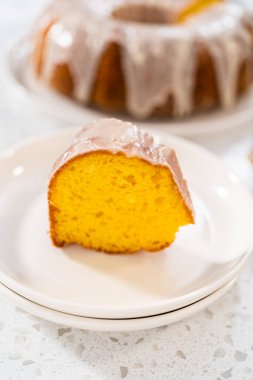 Dilimlenmiş vanilyalı kek, beyaz bir tabakta beyaz jöleli..