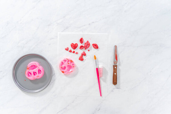 Flat lay. Dusting chocolate lips and heart-shaped chocolates with editable glitter for Valentines Day.