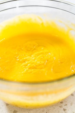 Basit bir vanilyalı kek pişirmek için malzemeleri cam bir kapta çırpma kabıyla karıştırıyorum..