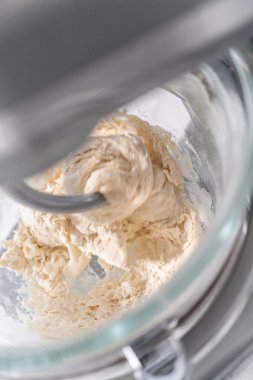 Büyük bir bardaktaki malzemeleri karıştırıyorum. Pizza hamuruyla karıştırıyorum..