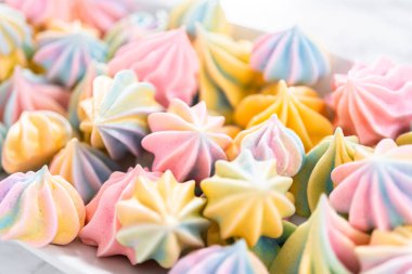 Beyaz servis tabağında çok renkli tek boynuzlu at kurabiyeleri..