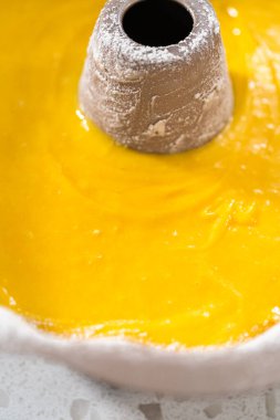 Basit bir vanilyalı kek pişirmek için yağlı kek tepsisine pasta hamuru döküyorum..