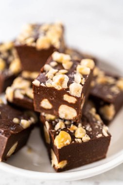 Beyaz tabakta ev yapımı çikolatalı fındıklı şekerleme parçaları..