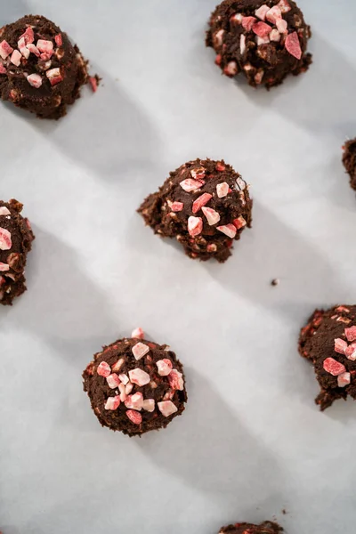 チョコレートクッキー生地を生地スクープですくってペパーミントチップでチョコレートクッキーを焼く — ストック写真