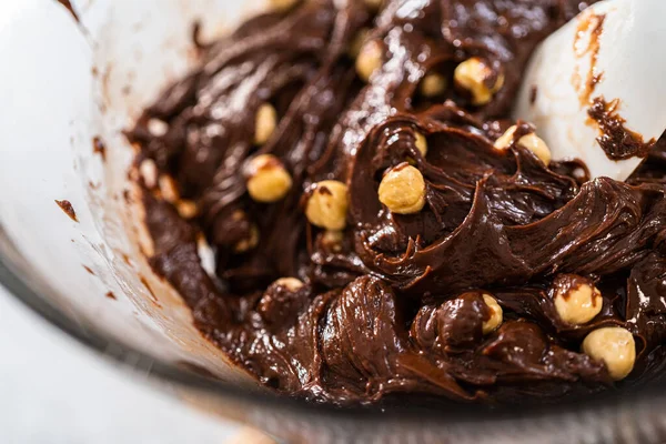 チョコレートのヘーゼルナッツ ファッジを調製するために沸騰した水の上にガラス混合ボウルにチョコレートチップやその他の成分を溶かす — ストック写真