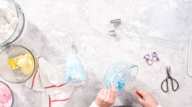 Düz yatıyordu. Adım adım. Tek boynuzlu at meringue kurabiyesi pişirmek için metal uçlu boru torbalarına krema karıştırılıyor..