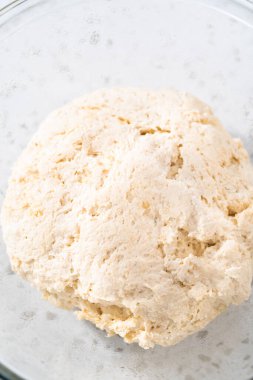 Cam bir kasede yükselen hamurlar naan dippers pişirmek için karıştırılıyor..