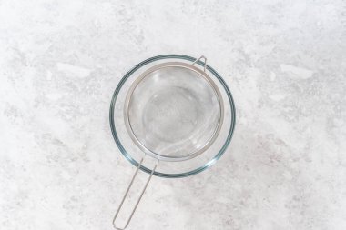 Düz yatıyordu. Yeni pişmiş boba incilerini süzgeç süzgecinden akıtıyor..