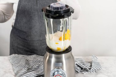 Mutfak blendırında mango boba smoothie hazırlamak için malzemeler karıştırılıyor.