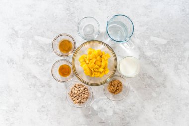 Düz yatıyordu. Mango boba smoothie hazırlamak için cam karıştırma kabında ölçülmüş malzemeler..