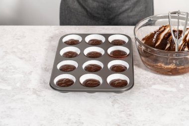 Çikolatalı çilekli kek pişirmek için kek hamurunu kek kaplarının içine atıyoruz..