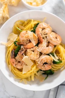 Beyaz seramik kaselerde ıspanaklı sarımsaklı karides makarnası servis ediyorum..