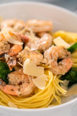 Beyaz seramik kaselerde ıspanaklı sarımsaklı karides makarnası servis ediyorum..