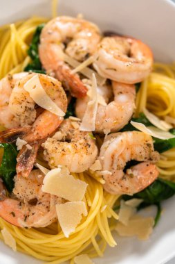 Beyaz seramik kaselerde ıspanaklı sarımsaklı karides makarnası servis ediyorum..