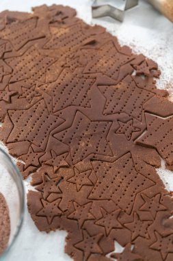 Kurabiye kesiciyle hamurdan yıldız şeklinde çikolatalı kraker kesmek..