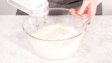 Adım adım. Tek boynuzlu at gökkuşağı çikolatalı kek yapmak için marketten alınmış krema kreması hazırlıyorum..