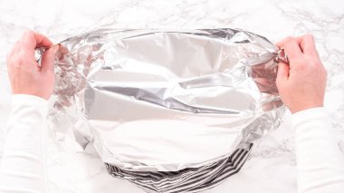 Düz yatıyordu. Adım adım. Pişmiş tavuğu servis etmeden önce folyoyla kaplamak..