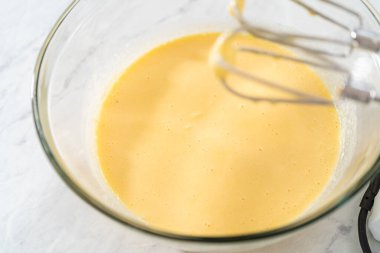 Limonlu yaban mersinli kek pişirmek için büyük bir bardakta ıslak malzemeler karıştırıyorum..