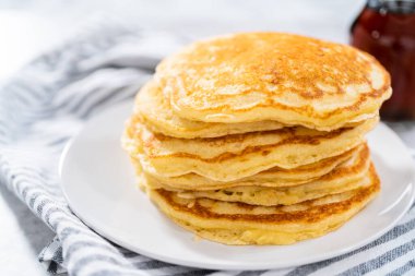 Dilimlenmiş muz, kızarmış hindistan cevizi ve akçaağaç şurubuyla süslenmiş taze hindistan cevizli krep yığını..