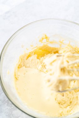 4 Temmuz pastasını çikolatalı yıldızlarla karıştırmak için cam bir kasenin içindekileri karıştırıyorum..