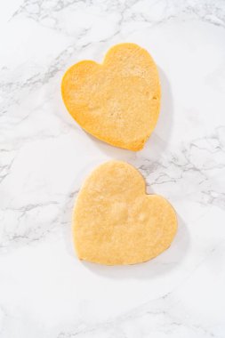 Sevgililer Günü için pembe ve beyaz kraliyet kremalı kalp şeklinde kurabiyeler..