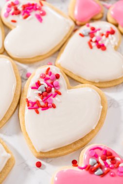 Sevgililer Günü için pembe ve beyaz kraliyet kremalı kalp şeklinde kurabiyeler..