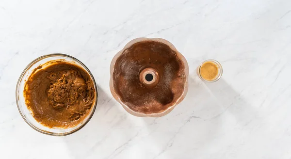 stock image Flat lay. Filling metal bundt cake pan with cake butter to bake gingerbread bundt cake with caramel filling.