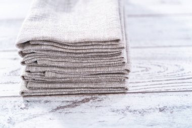 Ahşap beyaz bir masada doğal renkte keten bir peçetenin yakın görüntüsü..