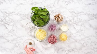 Düz yatıyordu. Adım adım. Ispanak ve jambonlu frittata hazırlamak için cam karıştırma kabındaki malzemeler..