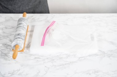 Nane şekerlerini beyaz bir kesim tahtasının üzerinde mermer bir raptiyeyle plastik bir çantada ezmek..