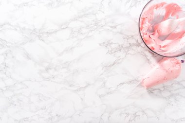 Düz yatıyordu. Pembe tereyağlı krema, mutfak ocunter 'ının üzerinde bir boru torbasında..