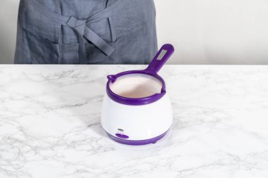 Çikolatalı kurabiyeler için çikolata kalpler yapmak için şekerlerin içinde kırmızı çikolata parçacıkları eritmek..