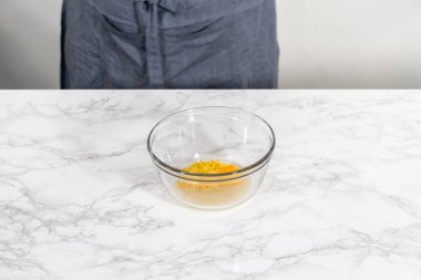 Lemon Cookies with White Chocolate. Mixing wet ingredients in a large glass mixing bowl to bake lemon cookies with white chocolate.