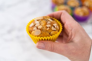 Mutfak tezgahında badem dilimleriyle süslenmiş taze pişmiş limonlu haşhaşlı çörekler..