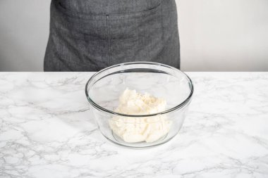 Naneli kremayı hazırlamak için cam bardakta tereyağı çırpma kreması karıştırma kabıyla elektrikli el mikseri..