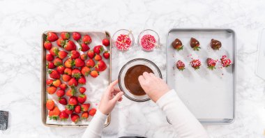 Düz yatıyordu. Çikolata kaplı çilekleri hazırlamak için erimiş çikolataya çilek bandırıyorum..