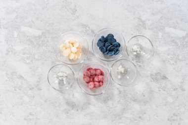 Düz yatıyordu. Ev yapımı çikolataları hazırlıyorum. Renkli çikolata cam kaselerde erir..