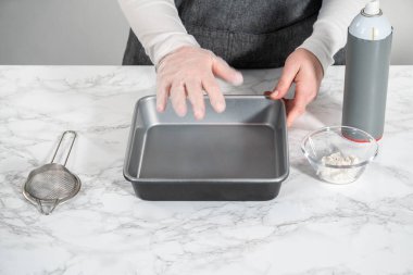 Kadehteki ölçülü malzemeler pişirmek için yağlanmış tavaya karıştırılıyor..