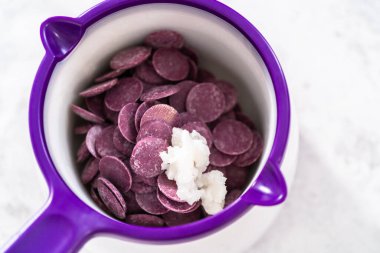 Melting chocolate chips in a candy melting pot to make mermaid pretzel twists.
