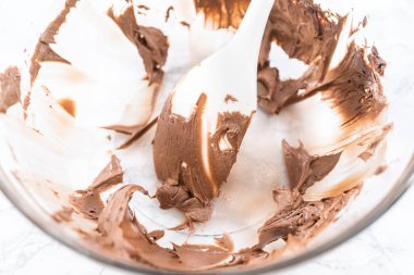 Marketten alınmış çikolatalı şekerlemeyi karıştırıyorum cam kaseyle karıştırıyorum..