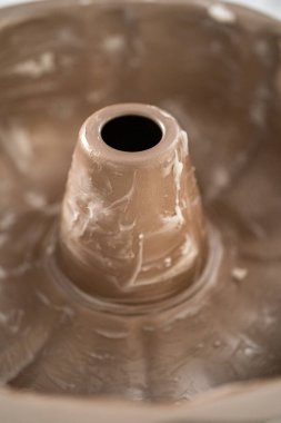 Kek pişirmek için metal tepsiyi yağlamak.