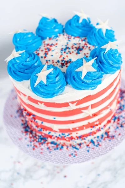 7月4日のお祝いのために白 青のバタークリームの霜降りでチョコレートケーキを飾る — ストック写真