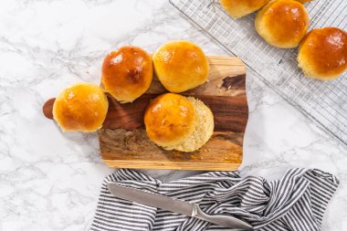 Düz yatıyordu. Odun kesme tahtasının üzerinde taze pişmiş çörekleri dilimliyorum..