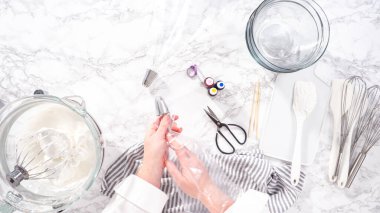 Adım adım. Düz yatıyordu. Tek boynuzlu at kurabiyesi pişirmek için besin boyasını kremaya karıştırıyorum..