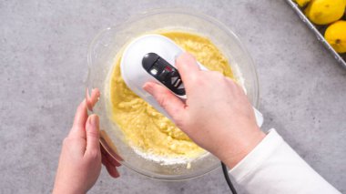 Düz yatıyordu. Adım adım. Limonlu kek hazırlamak için karıştırma kabının içindeki malzemeleri karıştırıyorum..