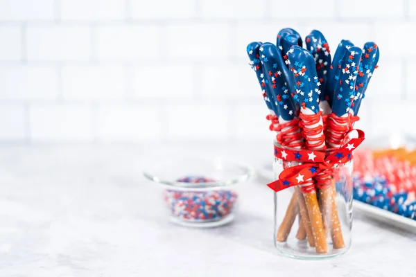 自制巧克力覆盖的椒盐卷饼棒 装饰得像玻璃瓶中的美国国旗 — 图库照片