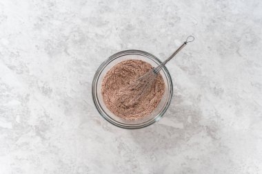 Flat lay. Mixing ingredients in a large glass mixing bowl to bake chocolate cookies with peppermint chips.