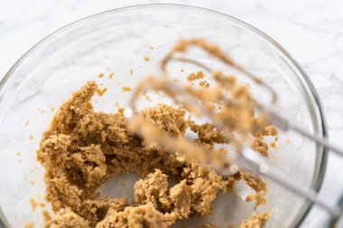 Büyük bir bardakta ıslak malzemeler karıştırarak kırmızı kadife kekler ve beyaz çikolatalı ganache kreması pişiriyorum..