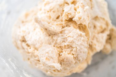 Büyük bir cam kasede ahşap bir kaşıkla karıştırılan malzemeler naan dippers pişirir..